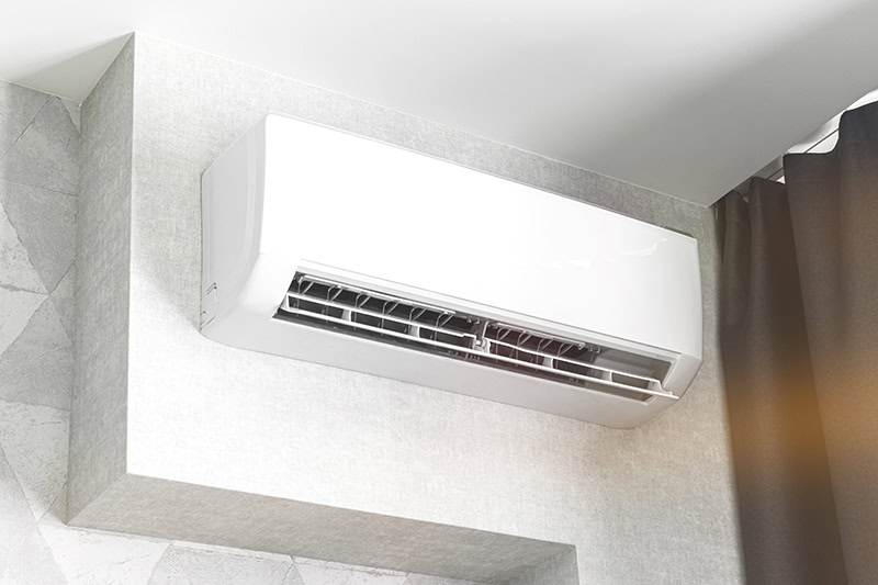 An indoor ductless mini-split air conditioning unit mounted high on a wall.